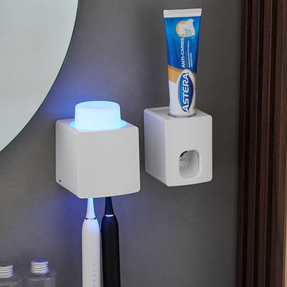 Two white square holders on a gray wall with a toothbrush and tube of toothpaste.