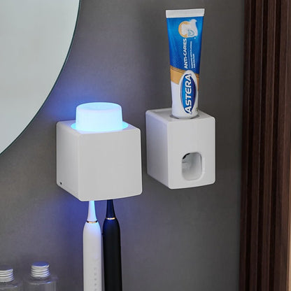 Two white square holders on a gray wall with a toothbrush and tube of toothpaste.
