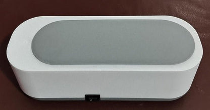 Rectangular white and gray electronic device on a brown surface