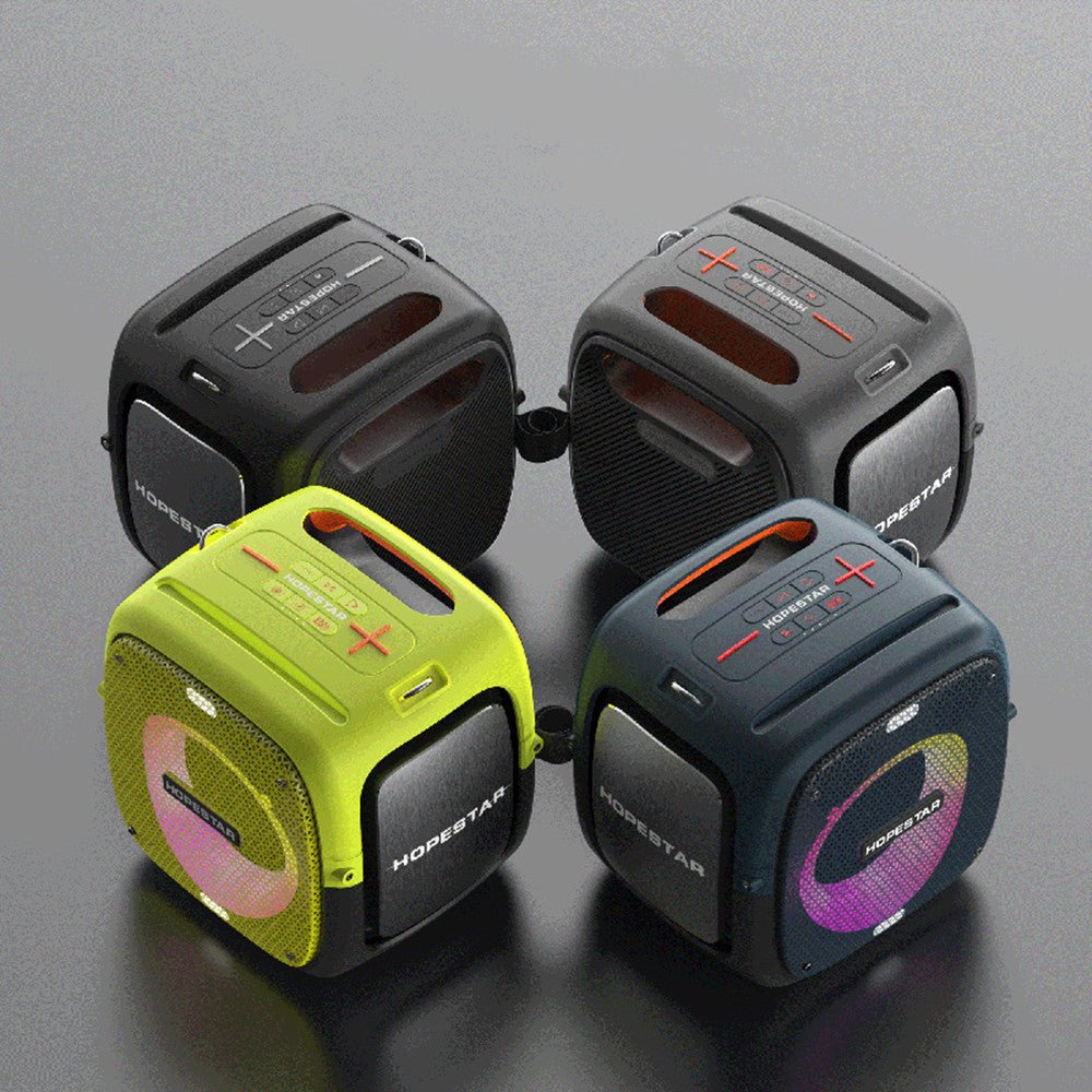 Four portable speakers in different colors on a gray background