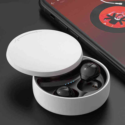 Wireless earbuds in a white charging case with a smartphone in the background.