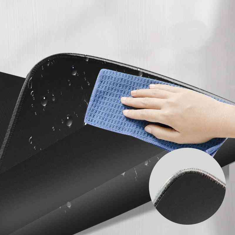 Hand using a blue microfiber cloth to clean a black surface with a close-up of the product.