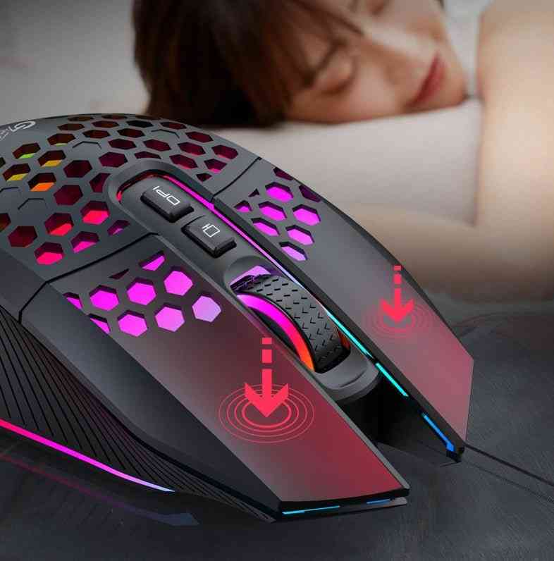 Gaming mouse with RGB lighting on a surface, blurred person in the background