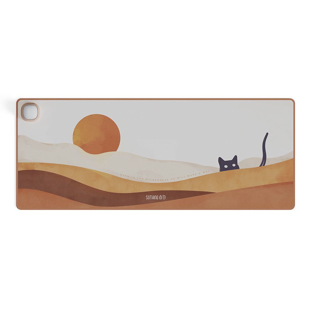 Desk mat with desert scene and cat design on a white background